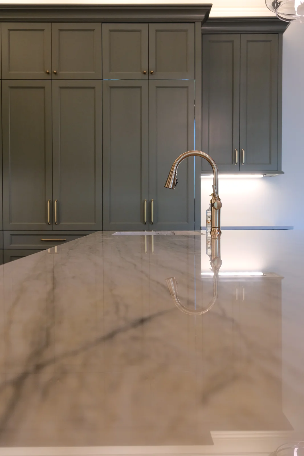 Kitchen faucet above a polished stone countertop
